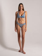 Slim-fit blue bikini on a poised model, clean aesthetic.