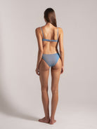 Elegant light blue striped bikini set with thin straps, showcasing a sleek back and slim silhouette. Perfect for beachwear and swimwear collections.