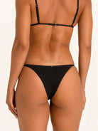 Back view of black bikini bottom with thong cut and seamless finish.