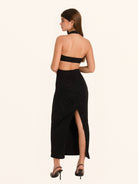 Rear side angle of black sequined cut out dress with back slit hem
