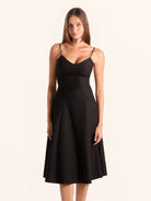 Front view of black spaghetti strap midi dress with flared hem