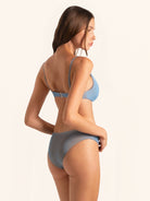 Back angle of blue grey bikini bottom with cheeky fit and textured fabric detail.