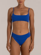 Front view of a woman wearing a vibrant blue bikini set featuring a square neckline top with thin adjustable straps and a high-waisted textured bottom for a sleek, flattering silhouette.
