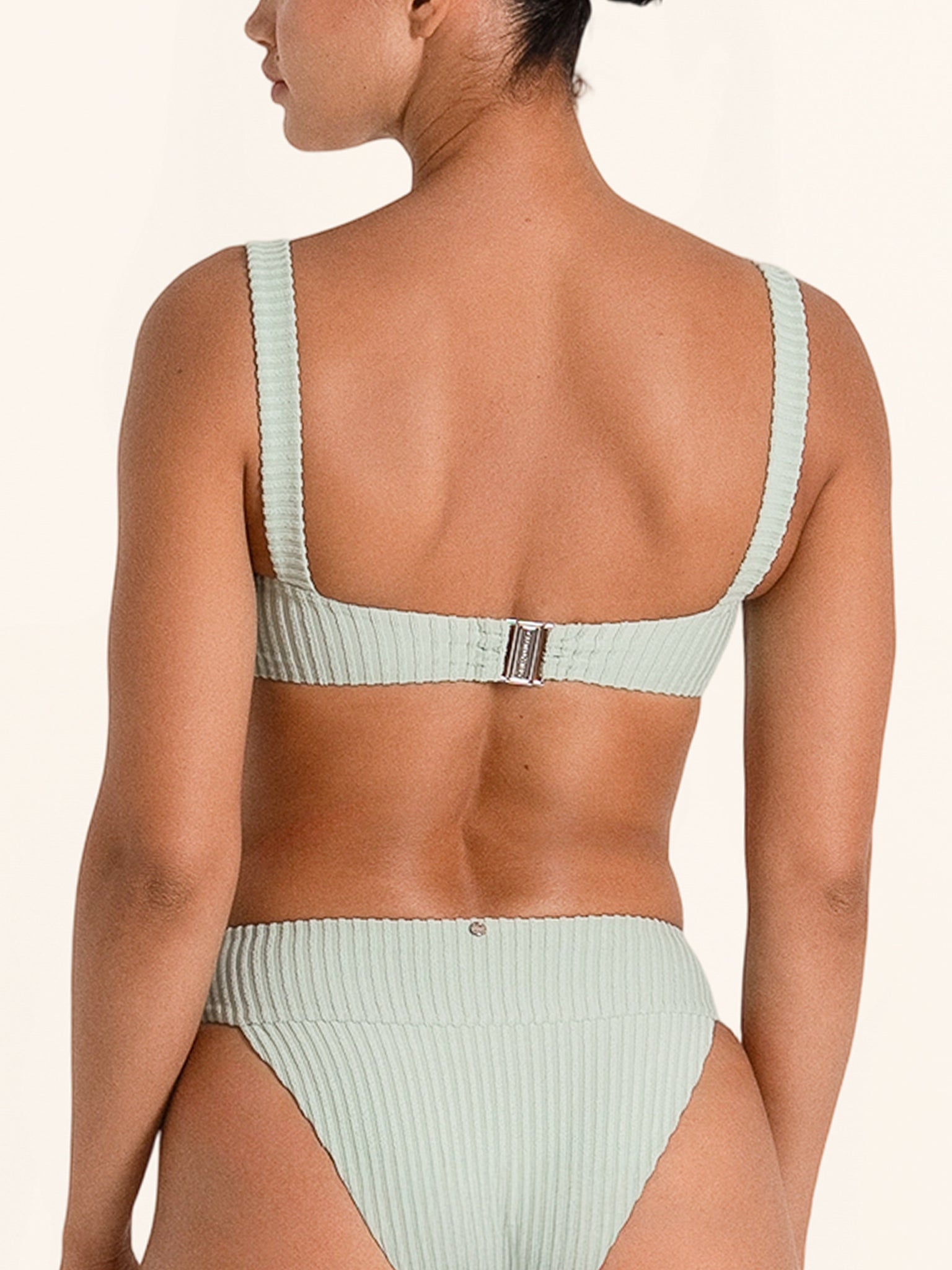 Chic light green swim top in twist style with modern fit.