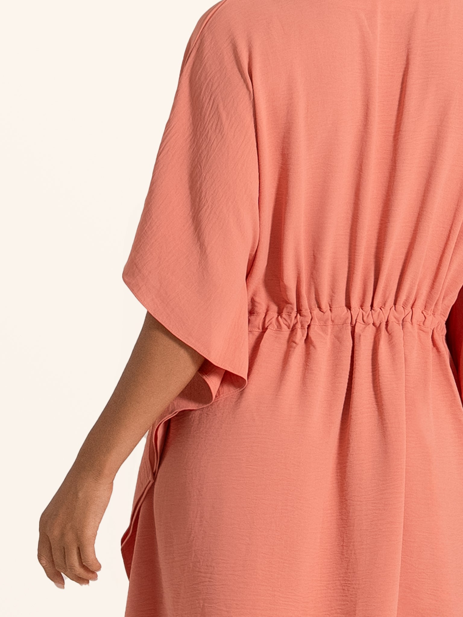 Back view of coral pink mini dress with elastic waist and relaxed silhouette