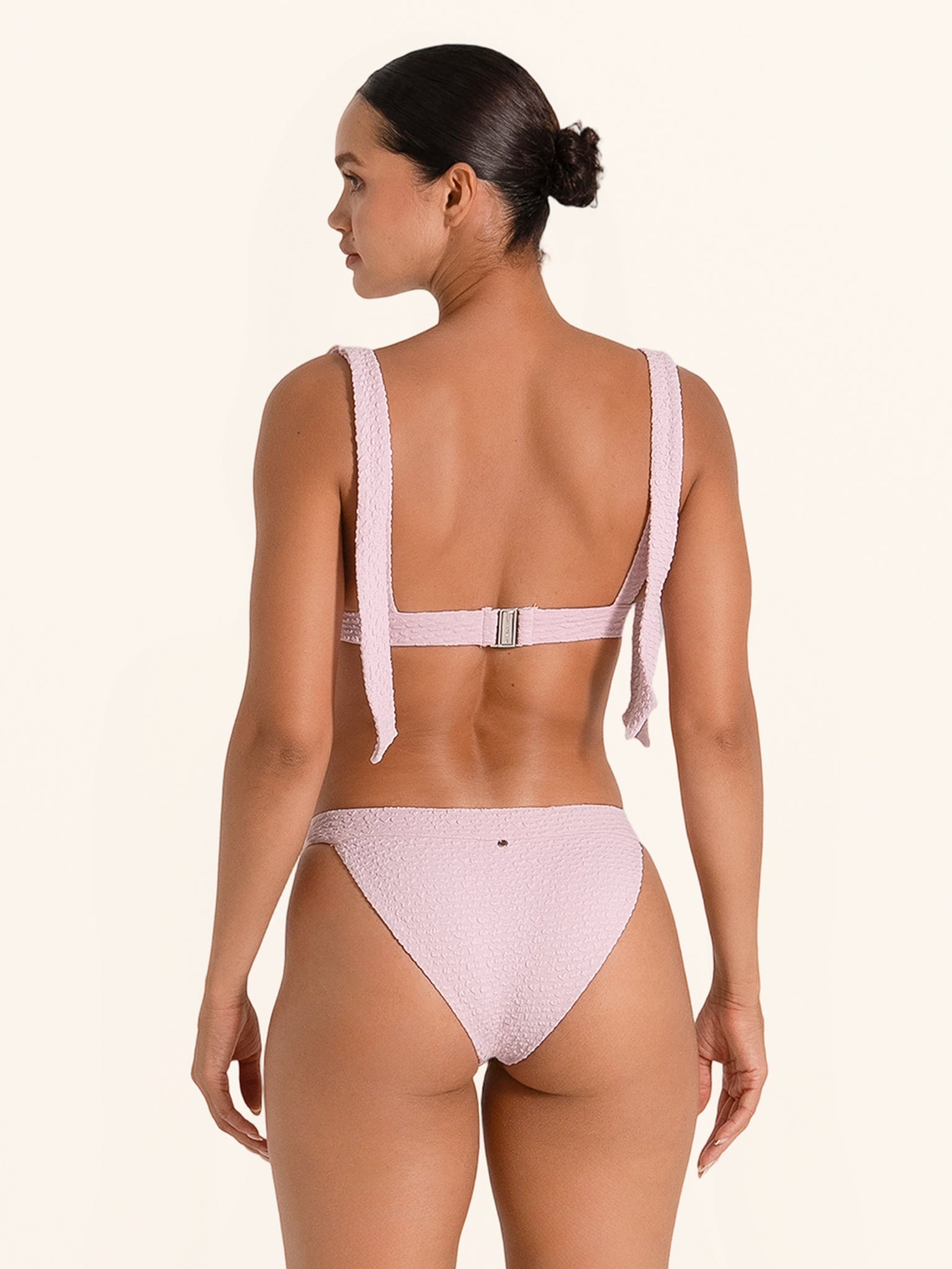 Dusty pink bikini top with bow shoulder accents in a flattering cut.