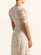 Side profile of floral midi dress featuring wrap front and flowy fit