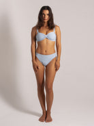 Front view of woman wearing a blue ribbed bikini set with thick straps top, and high-waisted bottoms