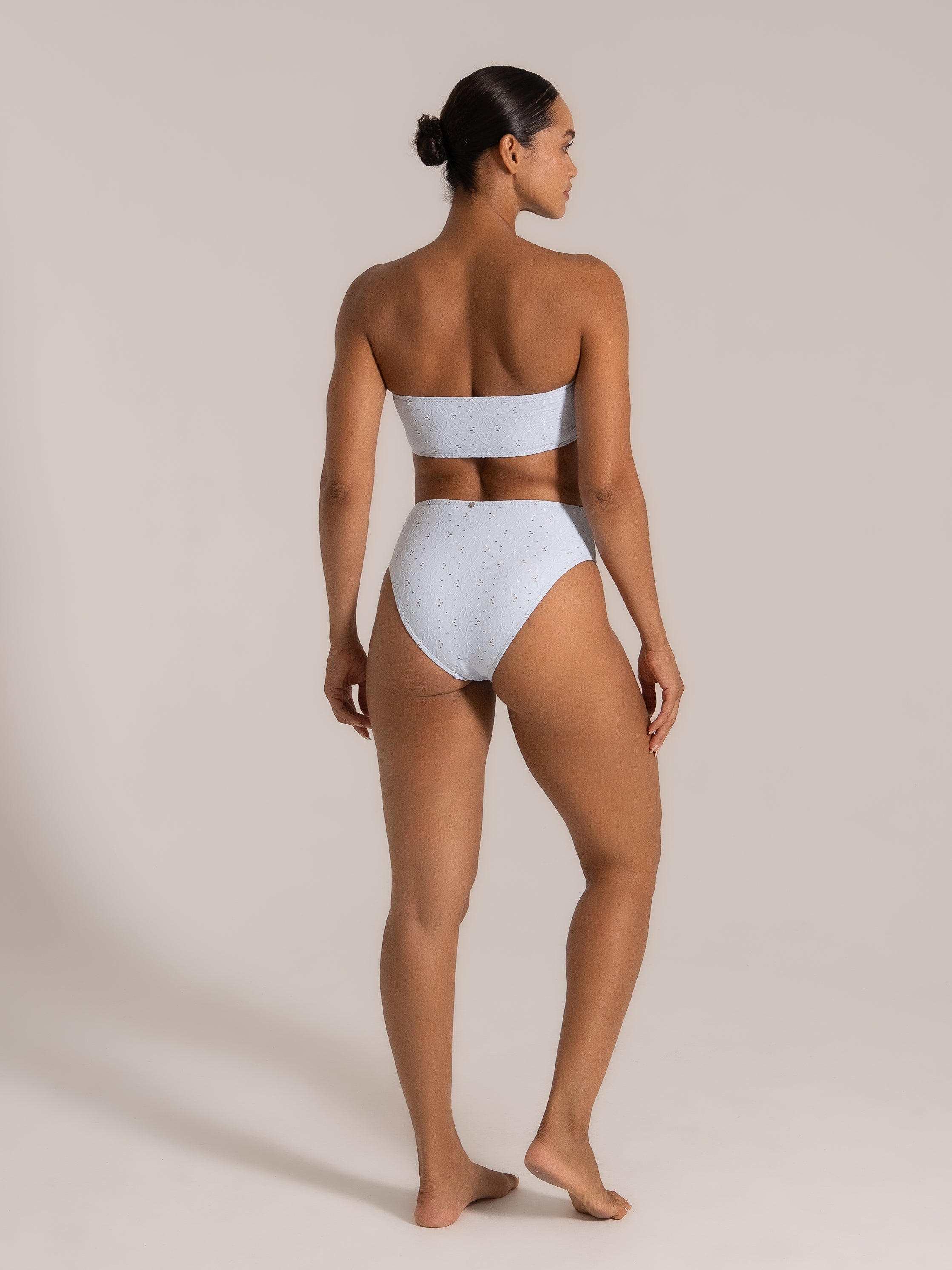 Side-back view of model in light blue lace strapless bikini