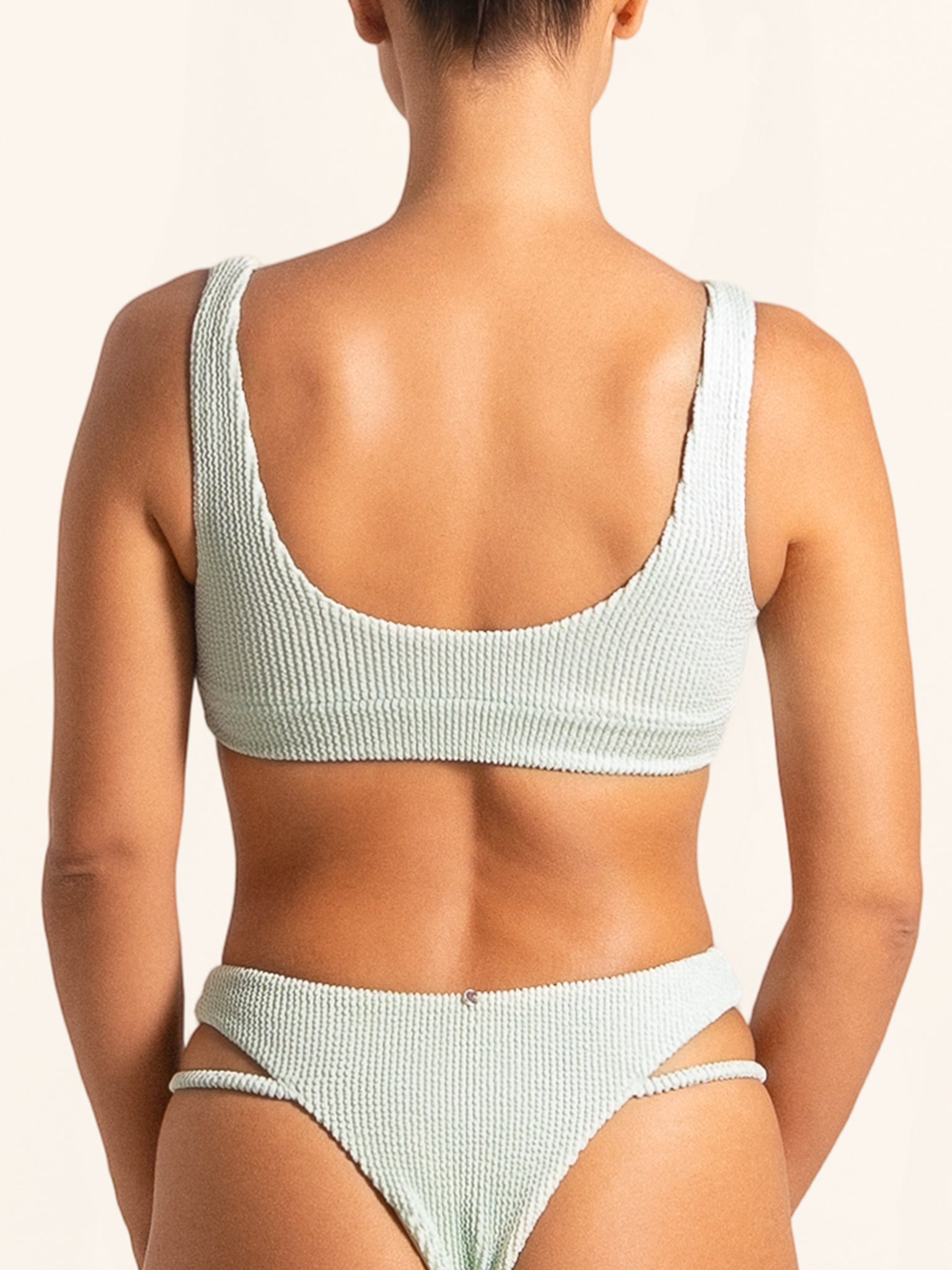 Side angle showing stylish cut-out detail on light green bikini top.