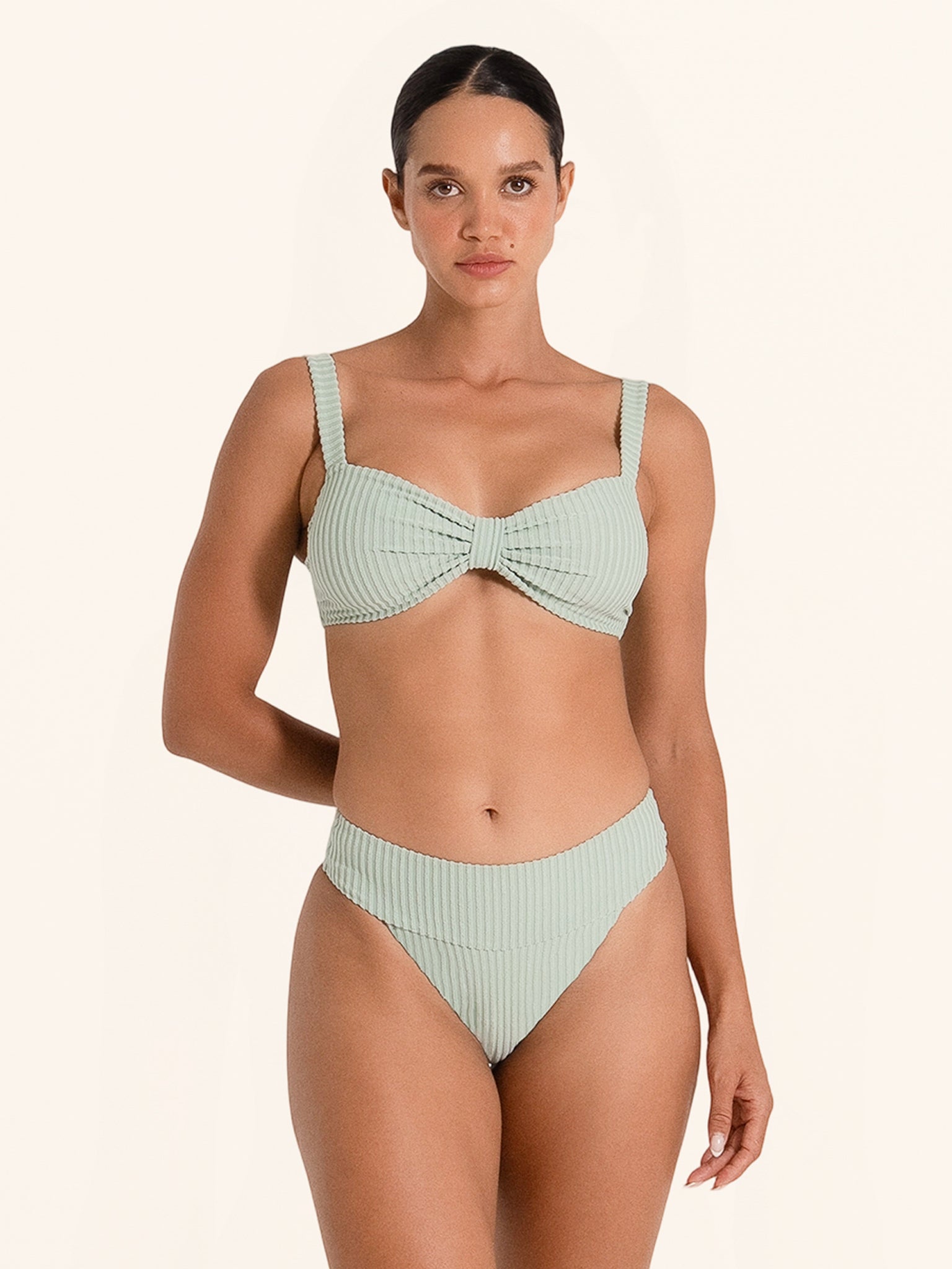 Light green bikini top with twist front detail and ribbed fabric.