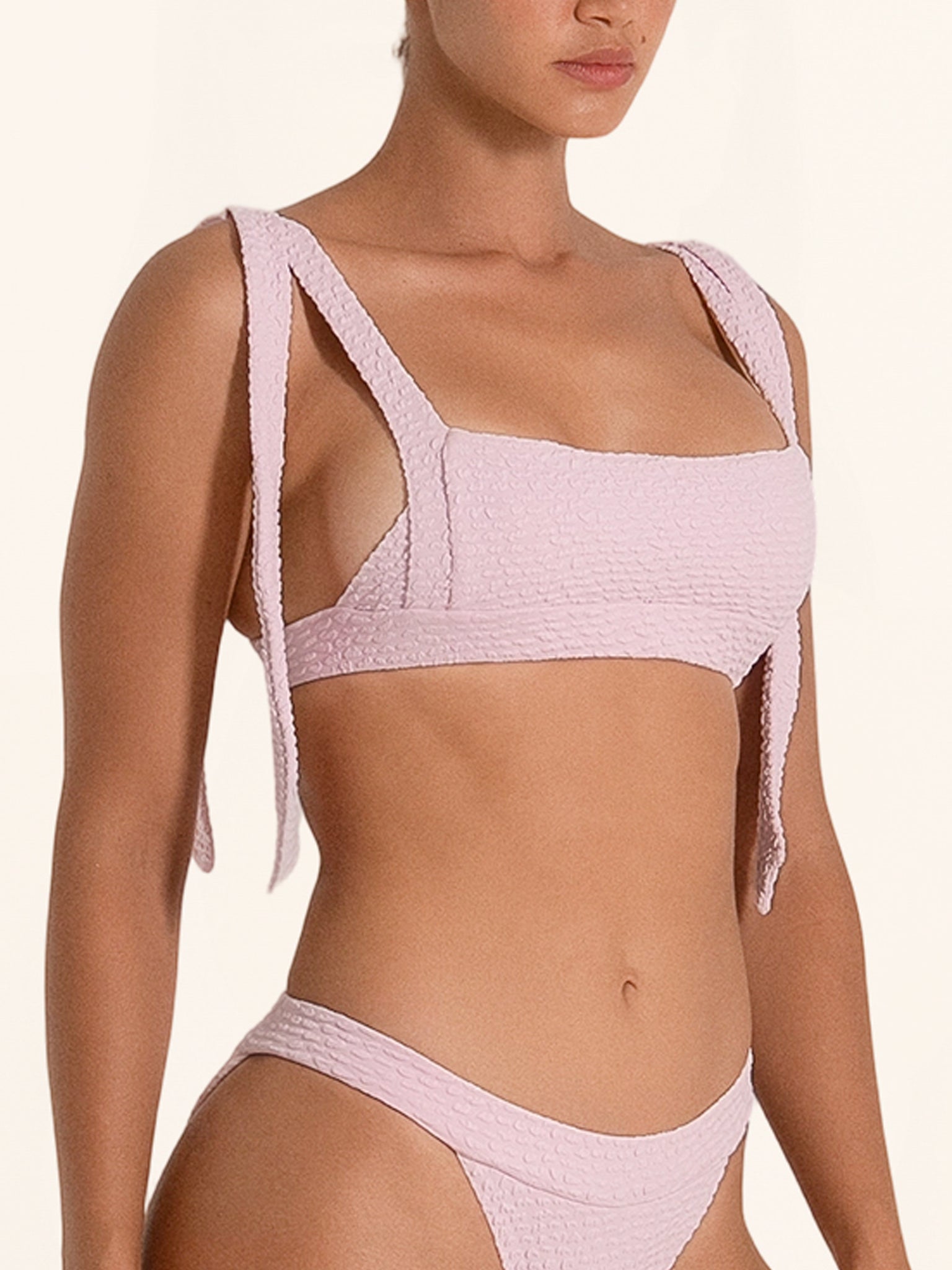 Light pink bikini top in a square neck design with feminine straps.