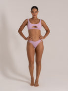 Model wearing lilac textured bikini with keyhole cut-out top and strappy bottom front view