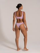 Back view of model wearing lilac bikini with scoop back and cheeky cut bottom
