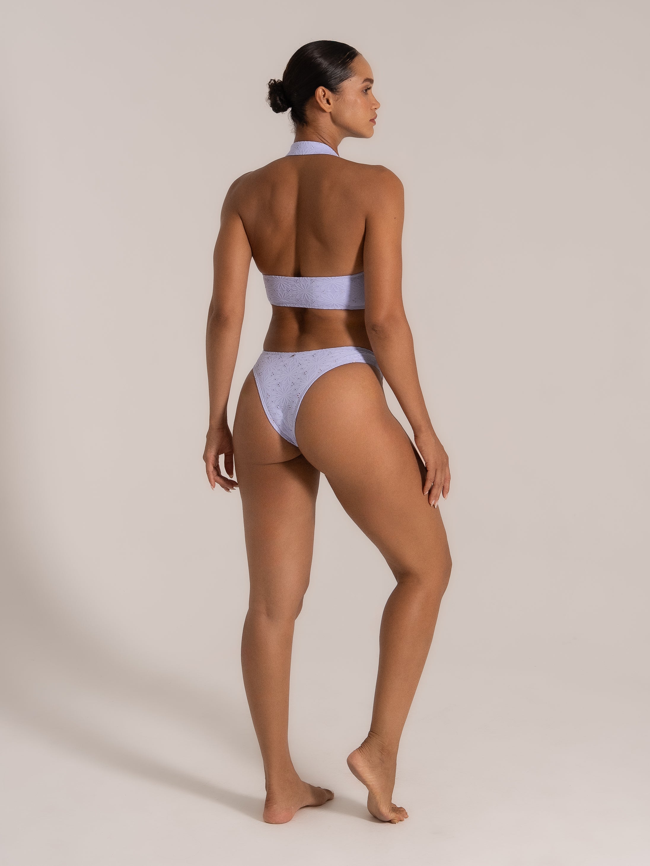 Angled back view of lilac halter bikini set with floral texture and wide band top