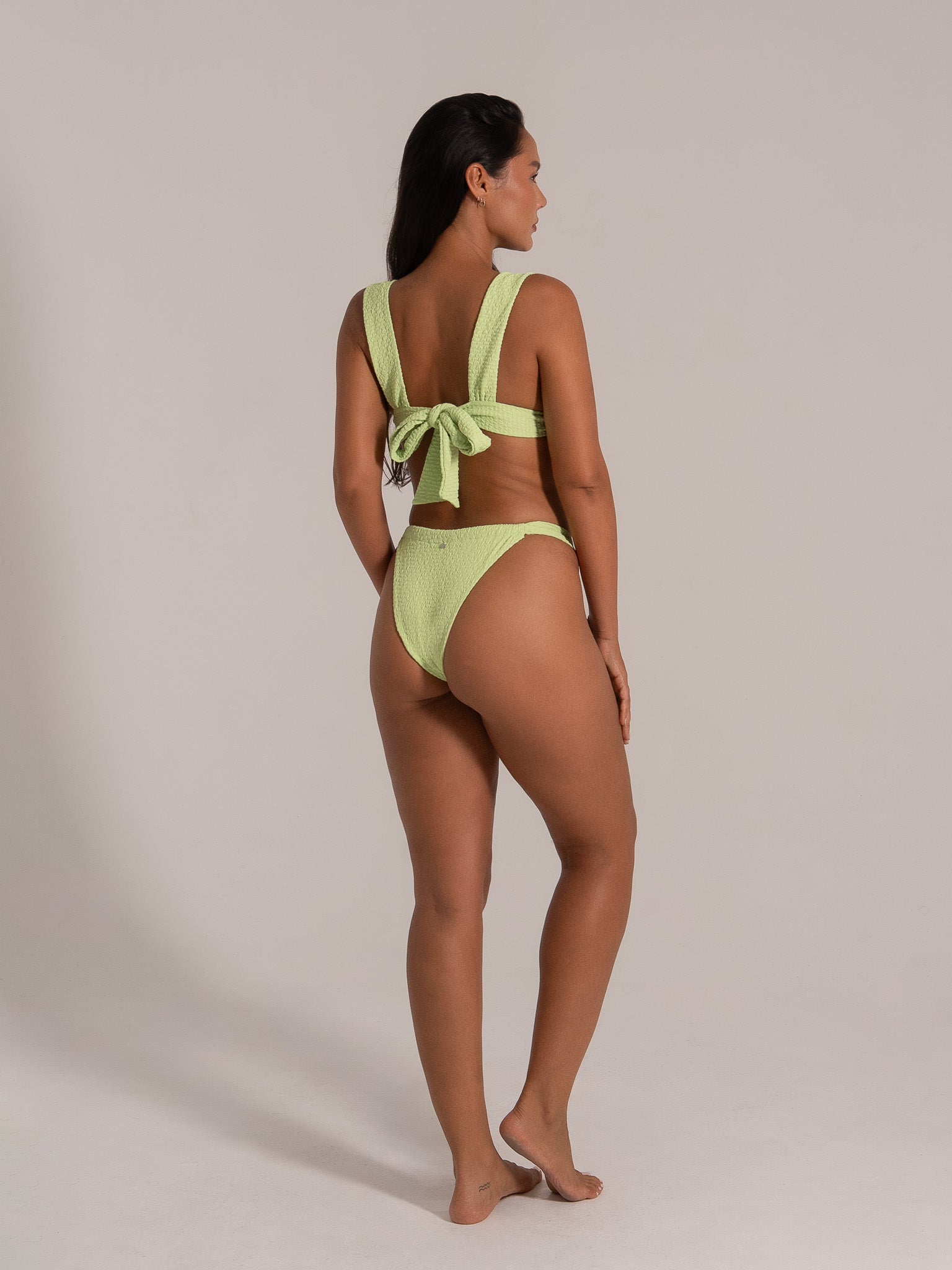 Back-tie bikini set in lime green textured fabric shown from side and back angle
