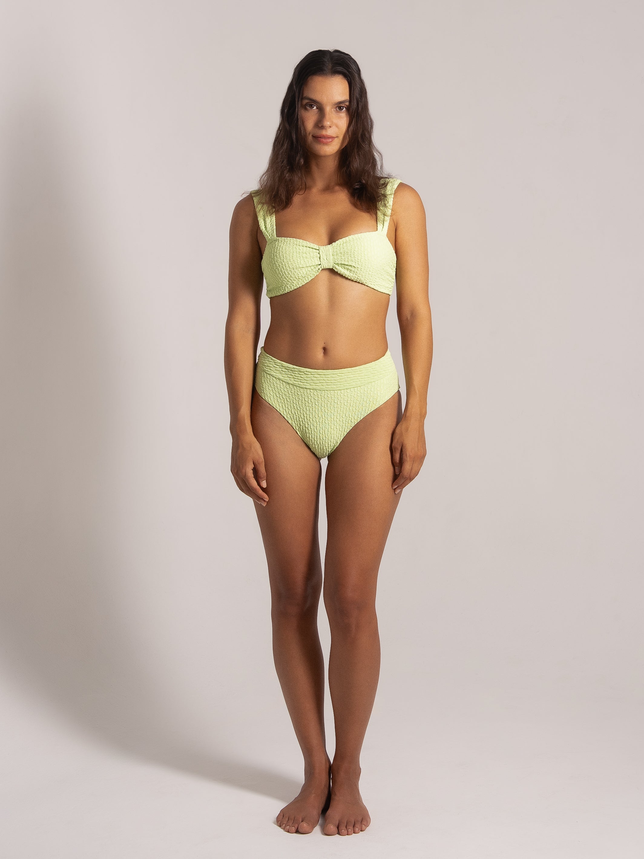 Woman wearing lime textured bikini set with wide straps and high-waisted bottom, front view