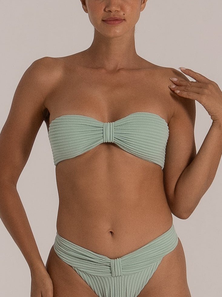 Close-up of a mint green bandeau bikini set featuring ruched detailing and textured ribbed fabric.