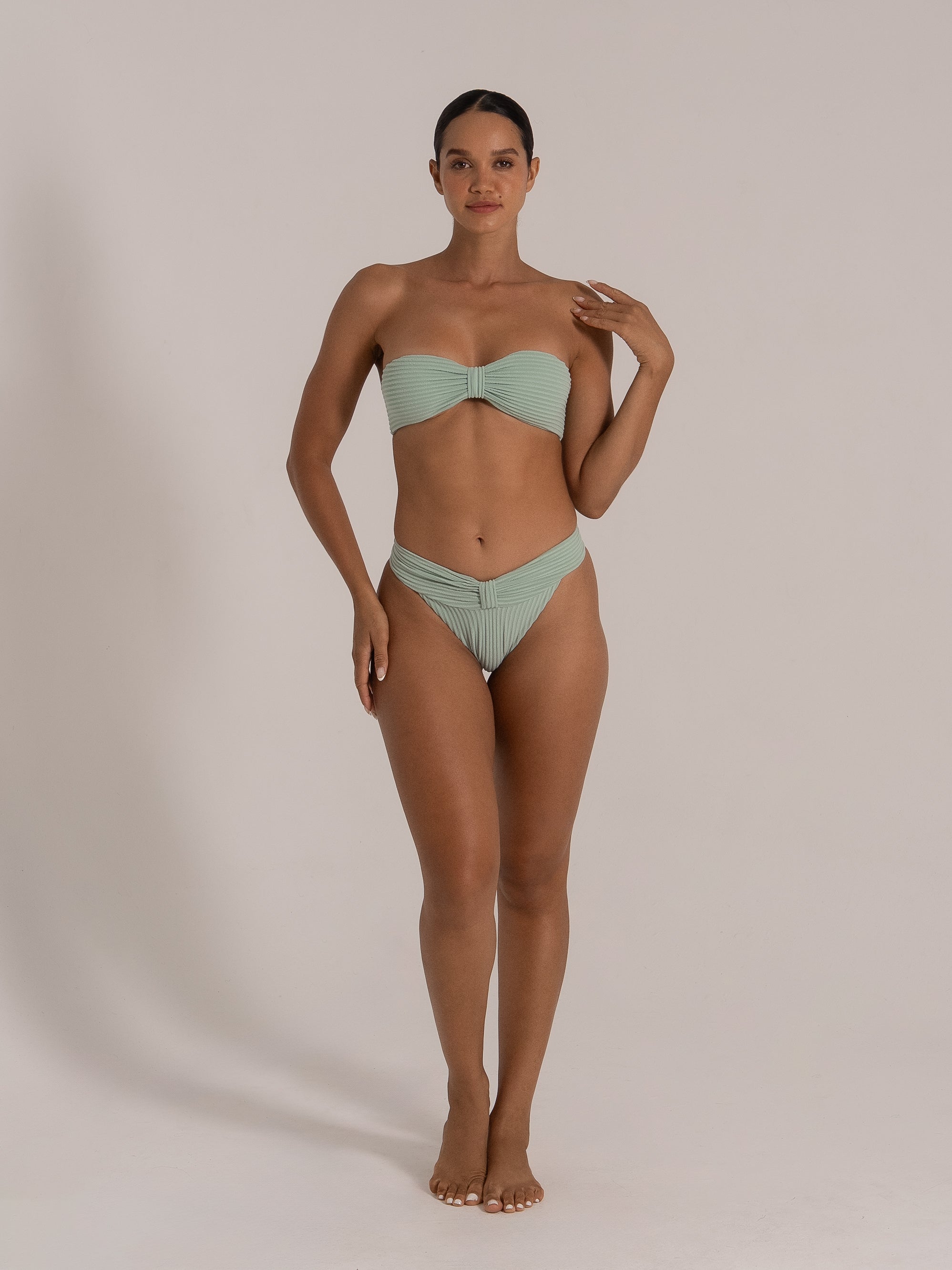 Full front view of model in mint green bandeau bikini set with gathered bandeau top and matching bottoms.