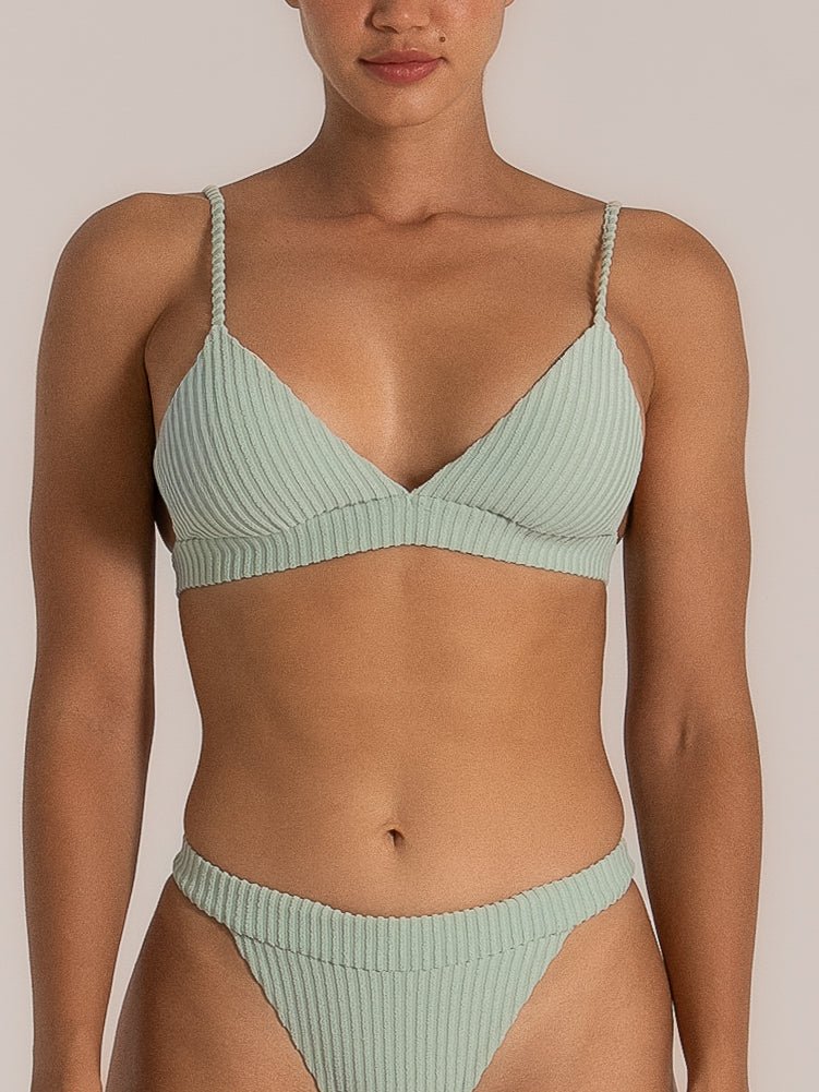 Front view of a woman wearing a mint green ribbed bikini set with a bralette-style top and high-cut bottoms featuring textured vertical lines and braided straps.