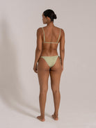 Woman wearing mint green ribbed bikini set from behind, showing tie side bottom and adjustable strap top