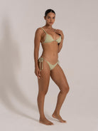 Side pose of model in mint green ribbed bikini with triangle top and tie side bottom