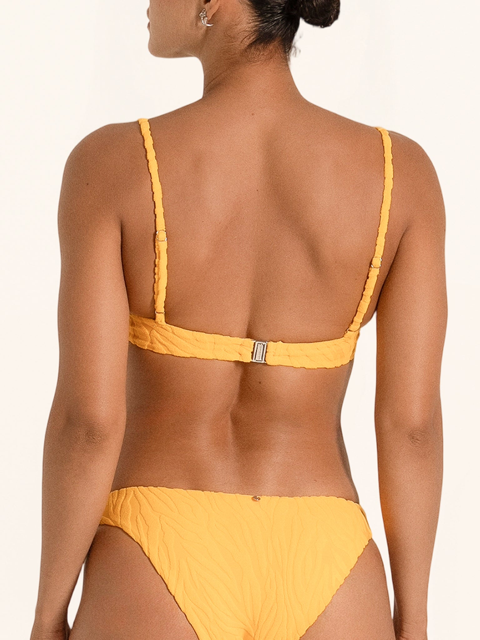 Back view of mustard yellow square neck bikini top with clasp closure and slim straps.