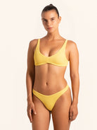 Front view of mustard yellow bikini top with textured fabric and square neckline.