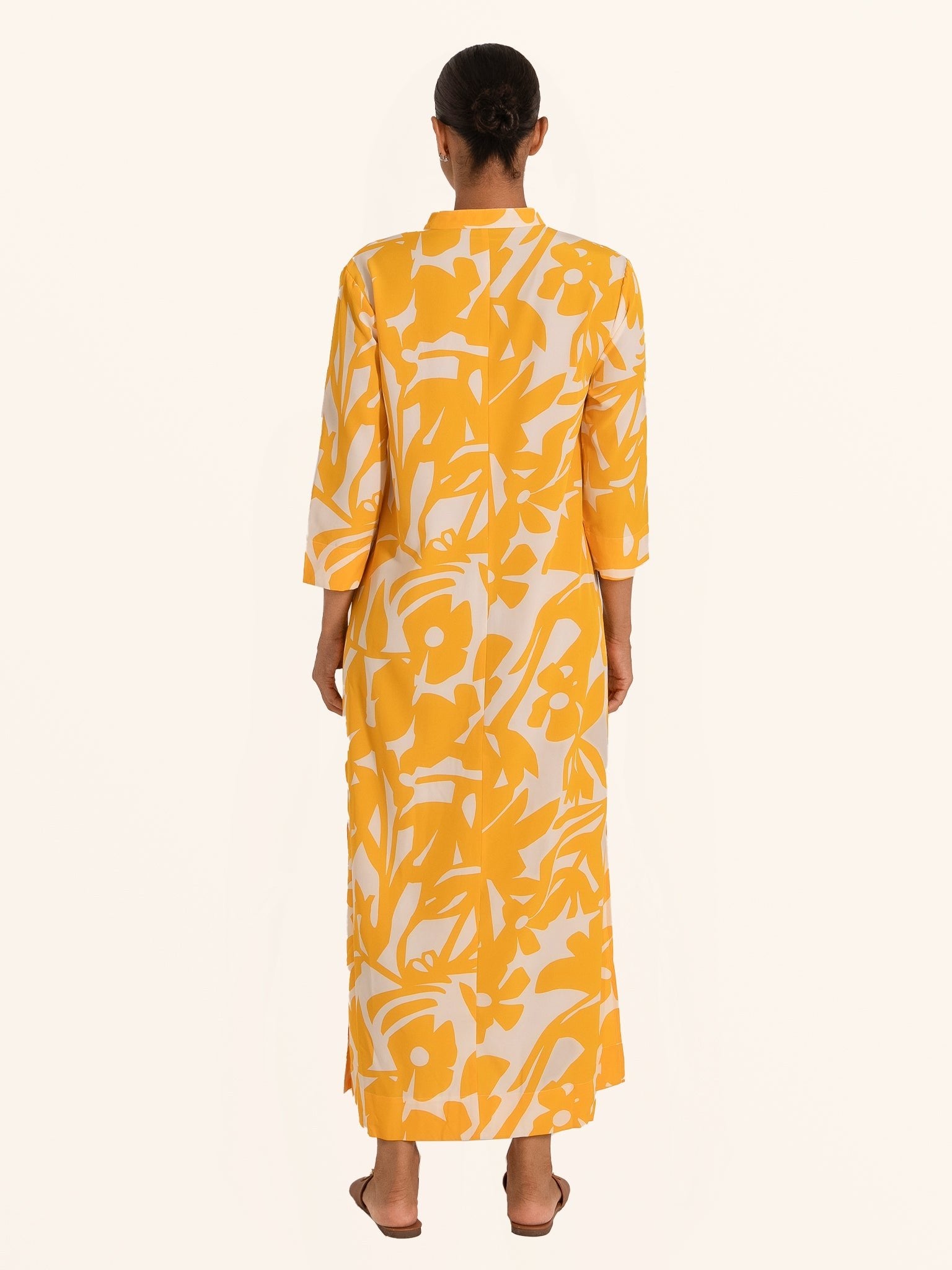 Rear full body view of mustard yellow floral maxi dress with relaxed silhouette