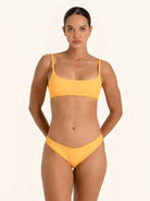 Front view of mustard yellow square neck bikini top with adjustable thin straps.