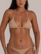 Close-up front view of a nude triangle bikini set with halter neck and adjustable side tie bottoms.