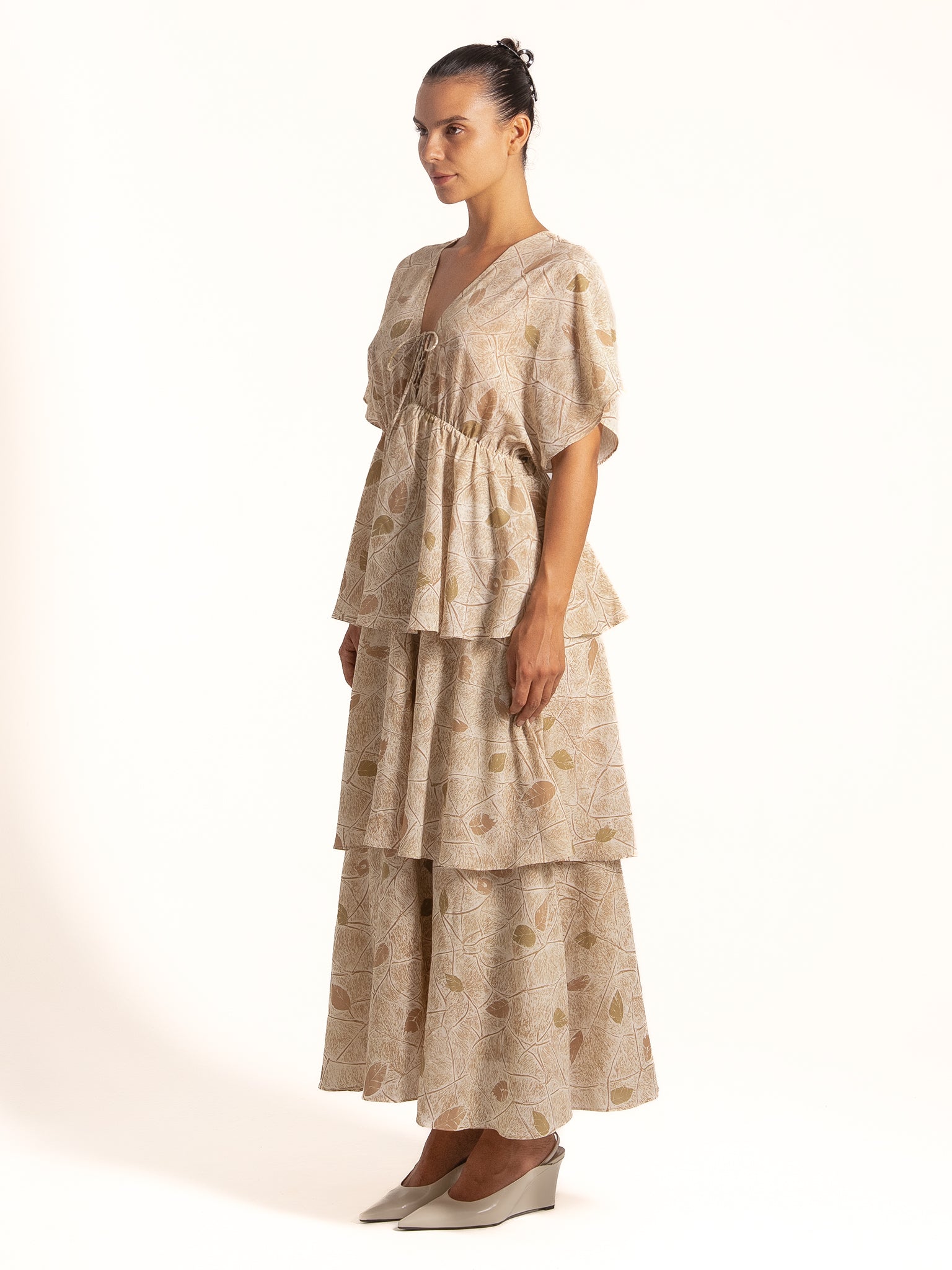 Side angle of Ocean Mystery beige floral maxi dress showcasing tiered skirt and lightweight flow.