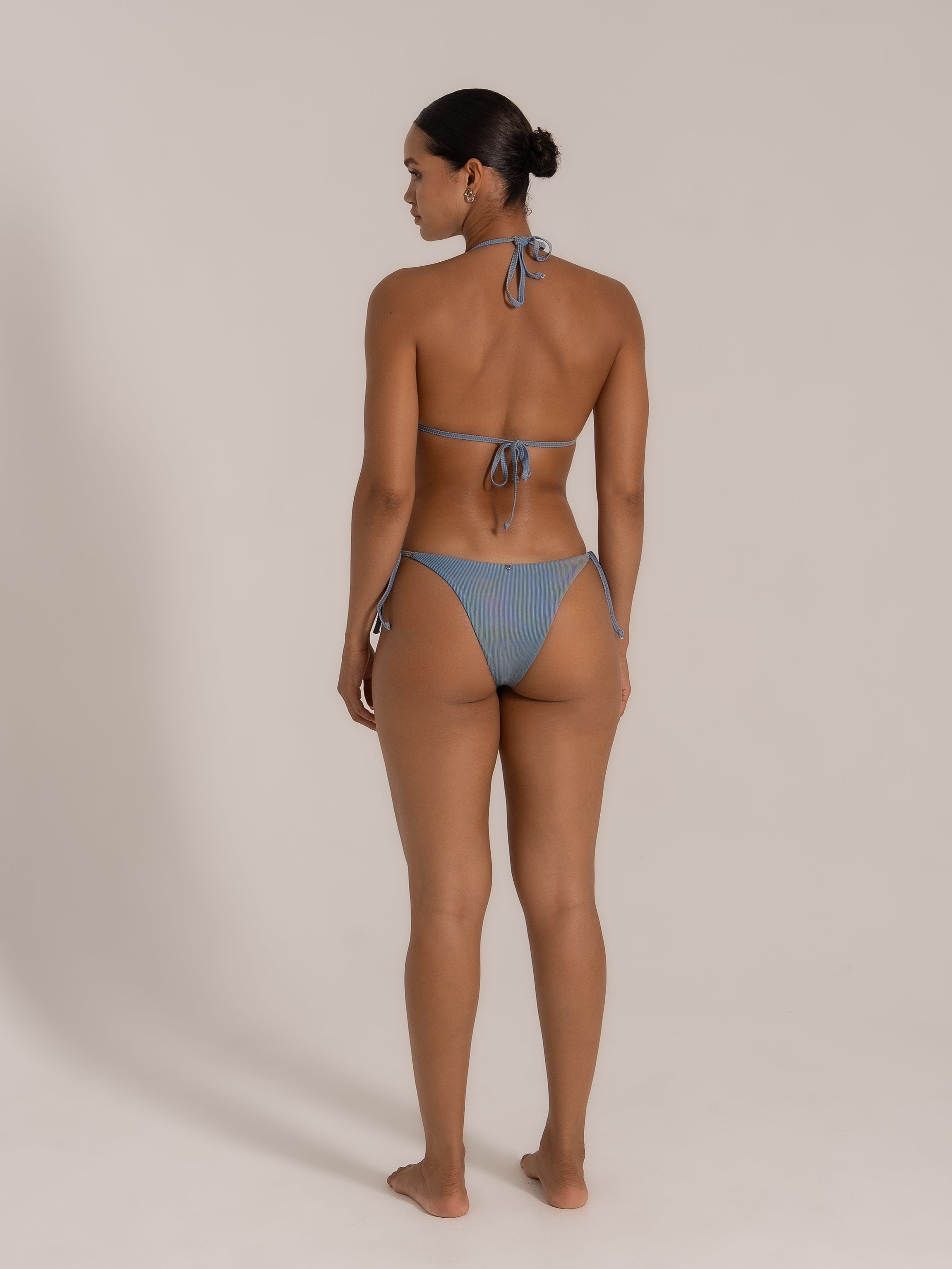 Back view of model wearing Ocean Mystery blue-grey textured triangle bikini with halter tie