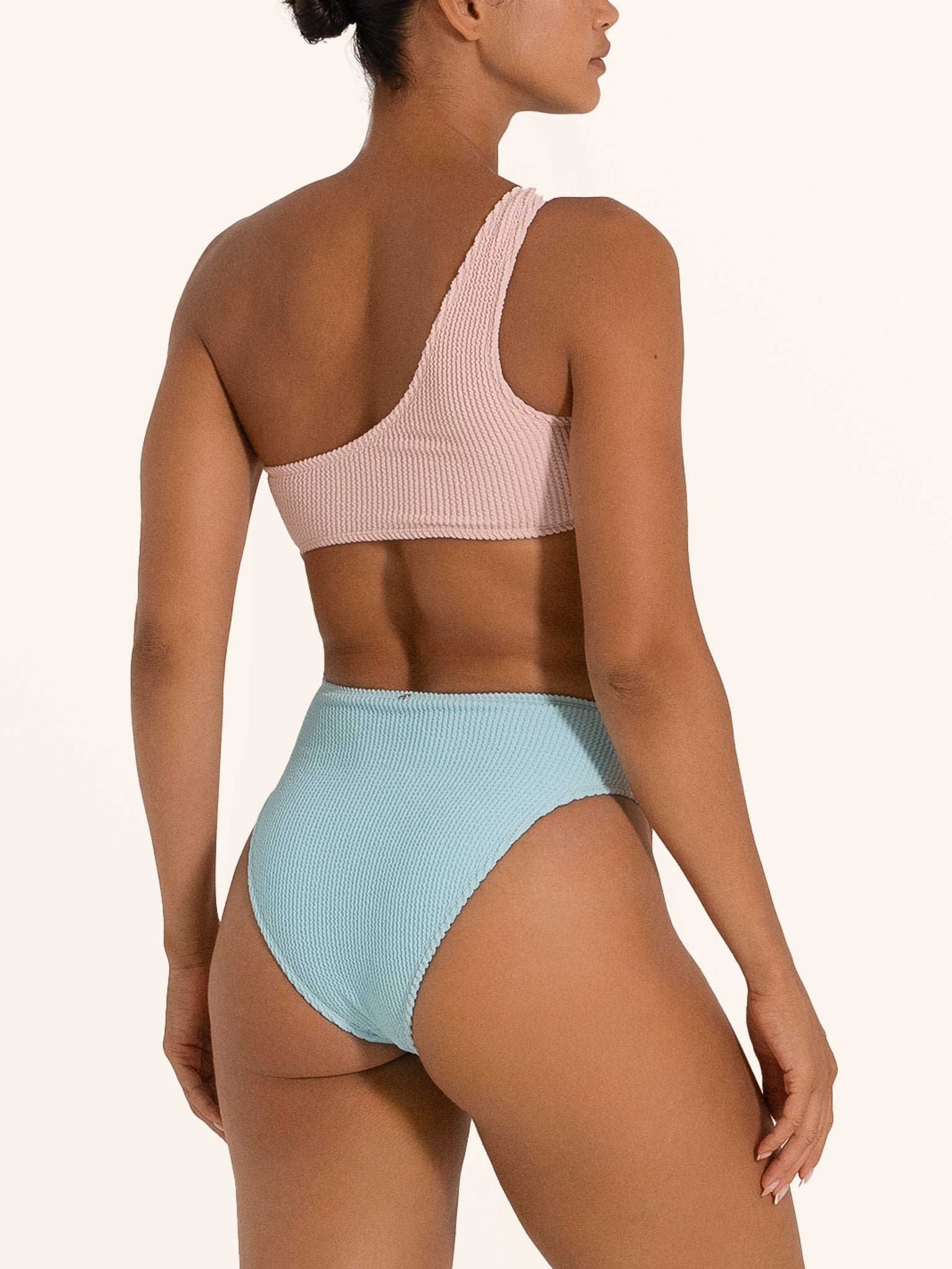 Side back view of Ocean Mystery asymmetric pink and blue cut out one piece swimsuit