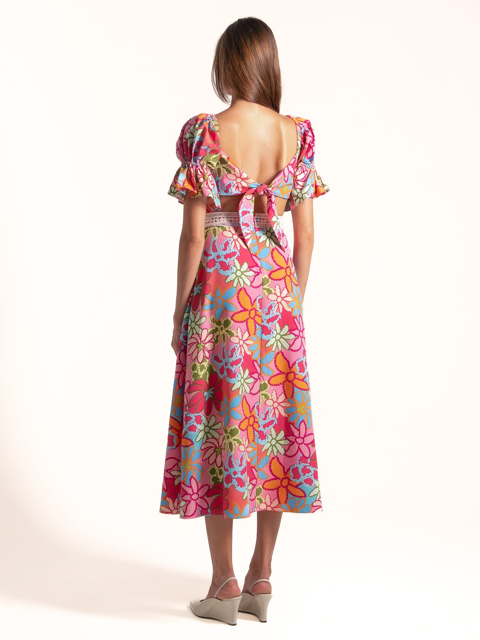 Model wearing Ocean Mystery pink floral puff sleeve midi dress with soft flowy fabric and romantic silhouette.