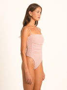 Model wearing Ocean Mystery red gingham one piece swimsuit with modern minimal silhouette.