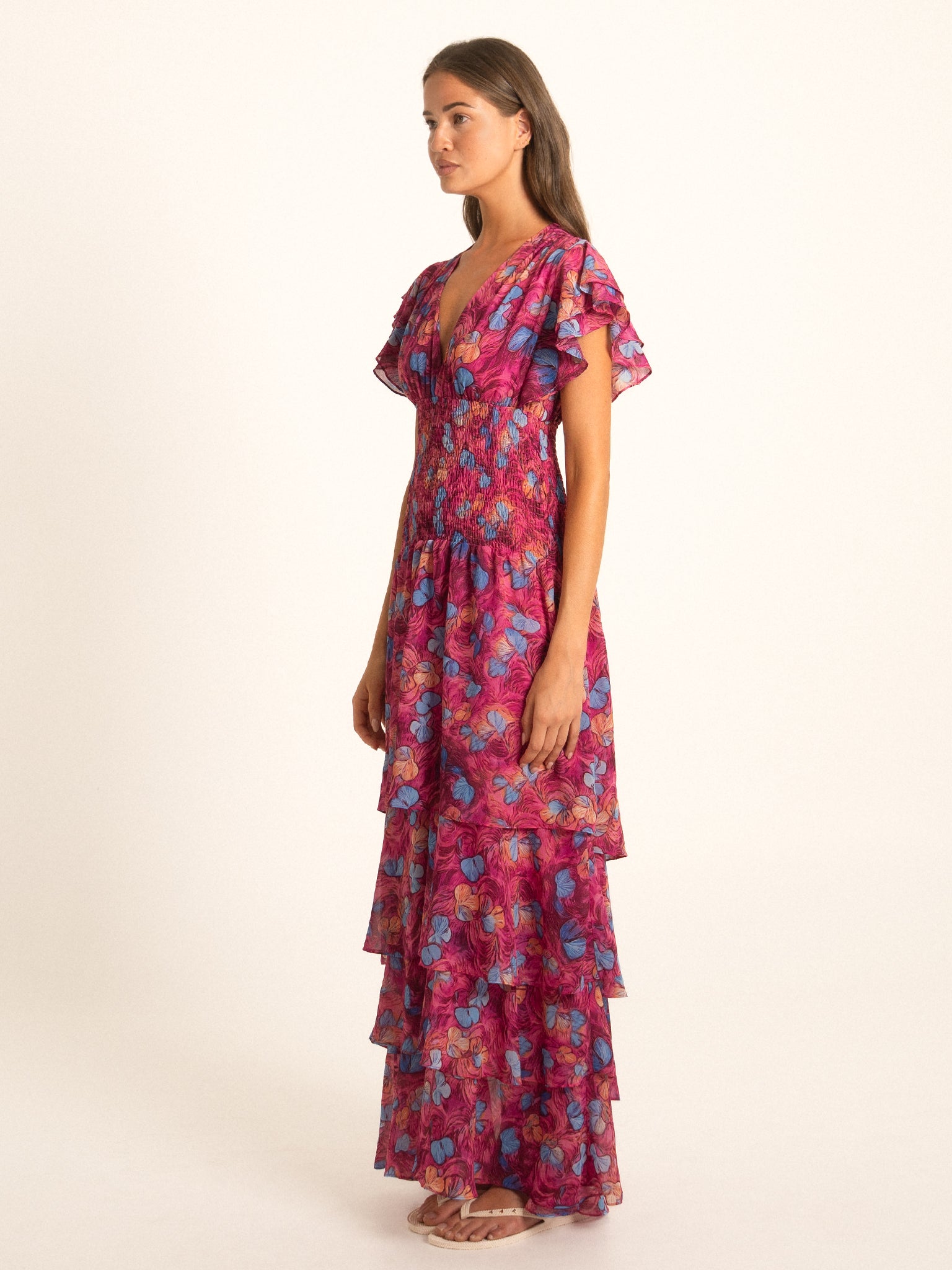 Ocean Mystery red and purple floral ruffle maxi dress with layered hem and short flutter sleeves, side view.
