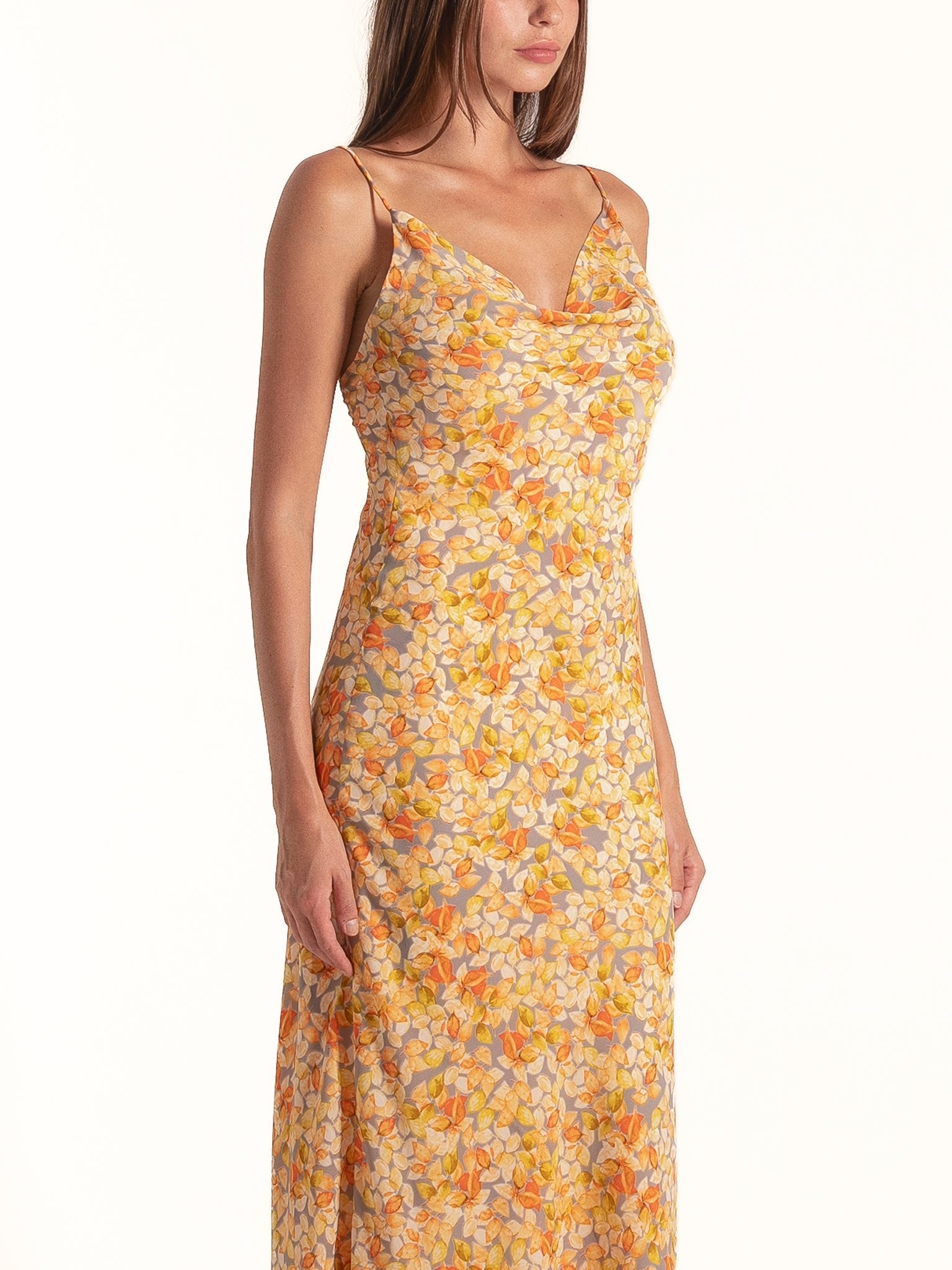 Side profile of Ocean Mystery yellow floral cowl neck midi dress featuring soft satin finish and elegant drape.
