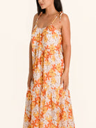 Side profile of orange floral maxi dress with relaxed fit and floral print