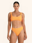 Orange swim top featuring wide straps and a supportive fit.