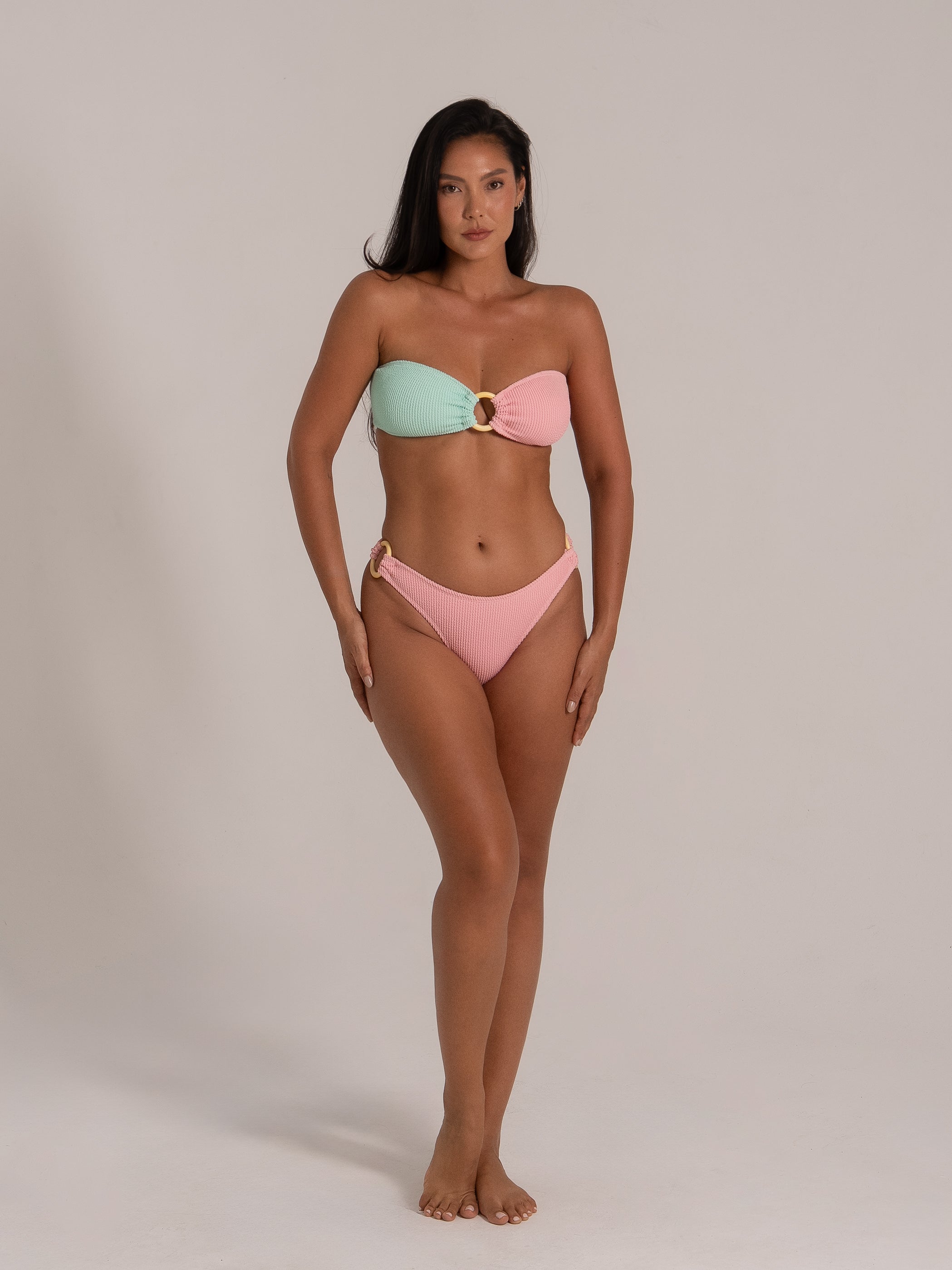 Front view of pastel mixed color bandeau bikini with decorative rings and textured finish
