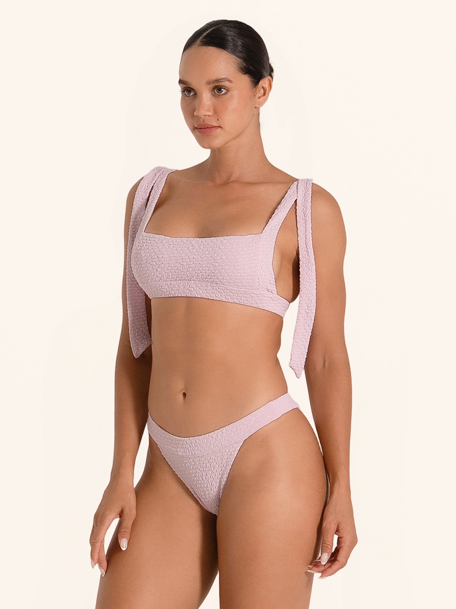 Pastel pink swim top featuring tie shoulder straps for adjustable fit.