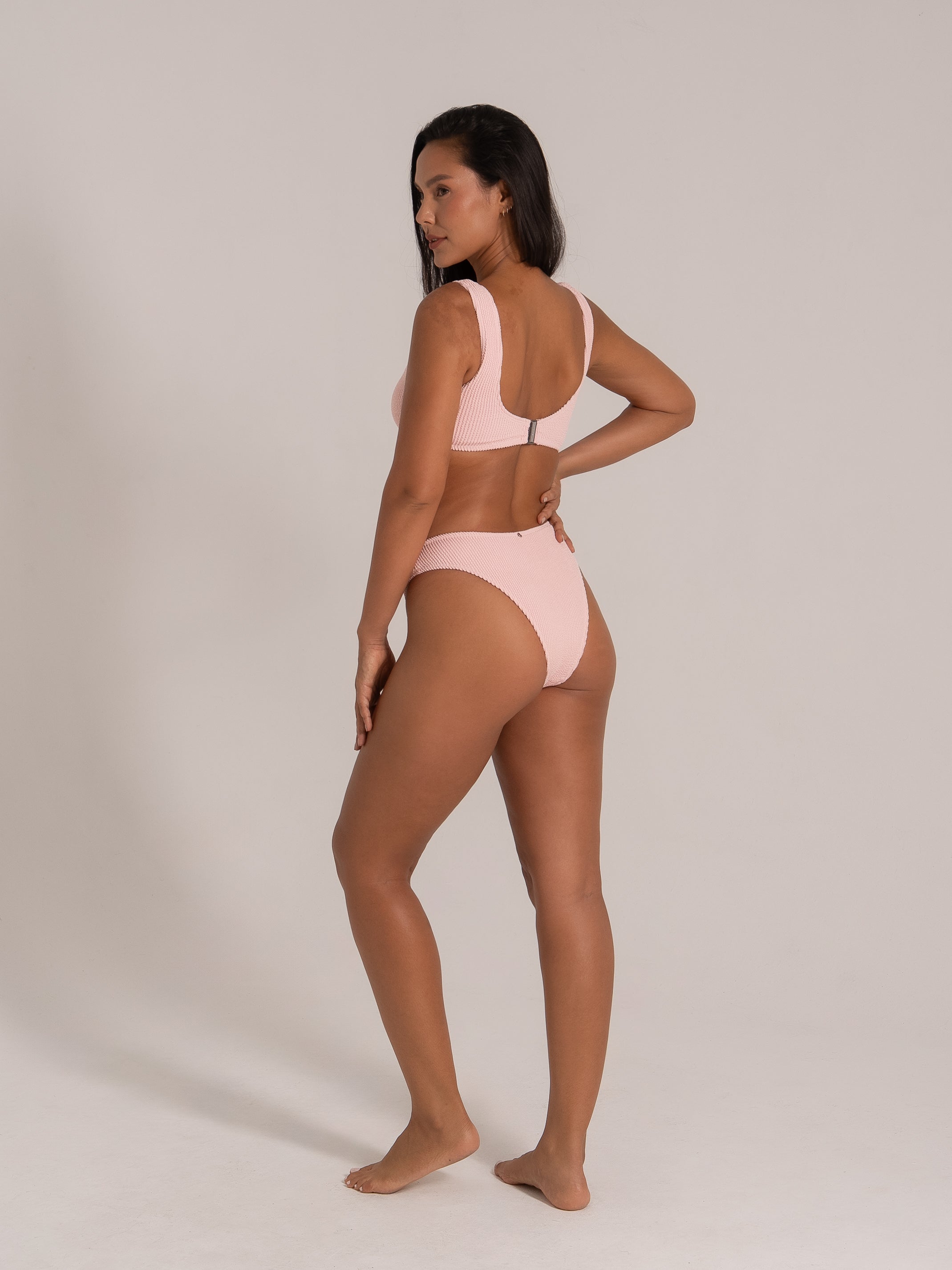 Angled back view of a pink ring bikini set with wide shoulder straps and high-waisted bottoms.