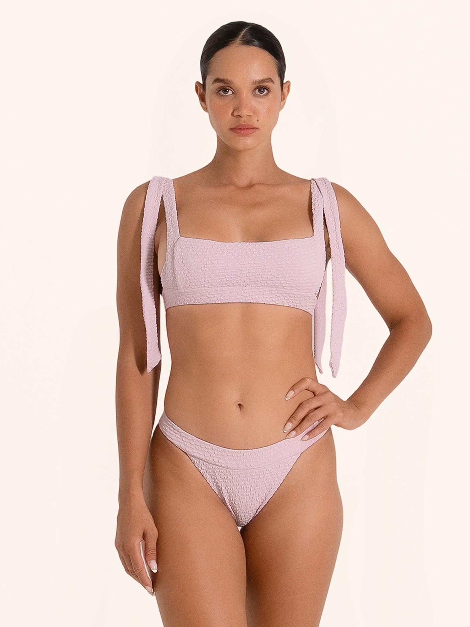 Pink bikini top with wide straps and bow tie shoulder detail.