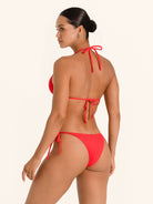 Flirty red bikini bottom with slim side tie straps and textured fabric.