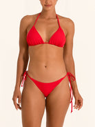 Front view of red tie side bikini bottom with low rise fit and adjustable straps.