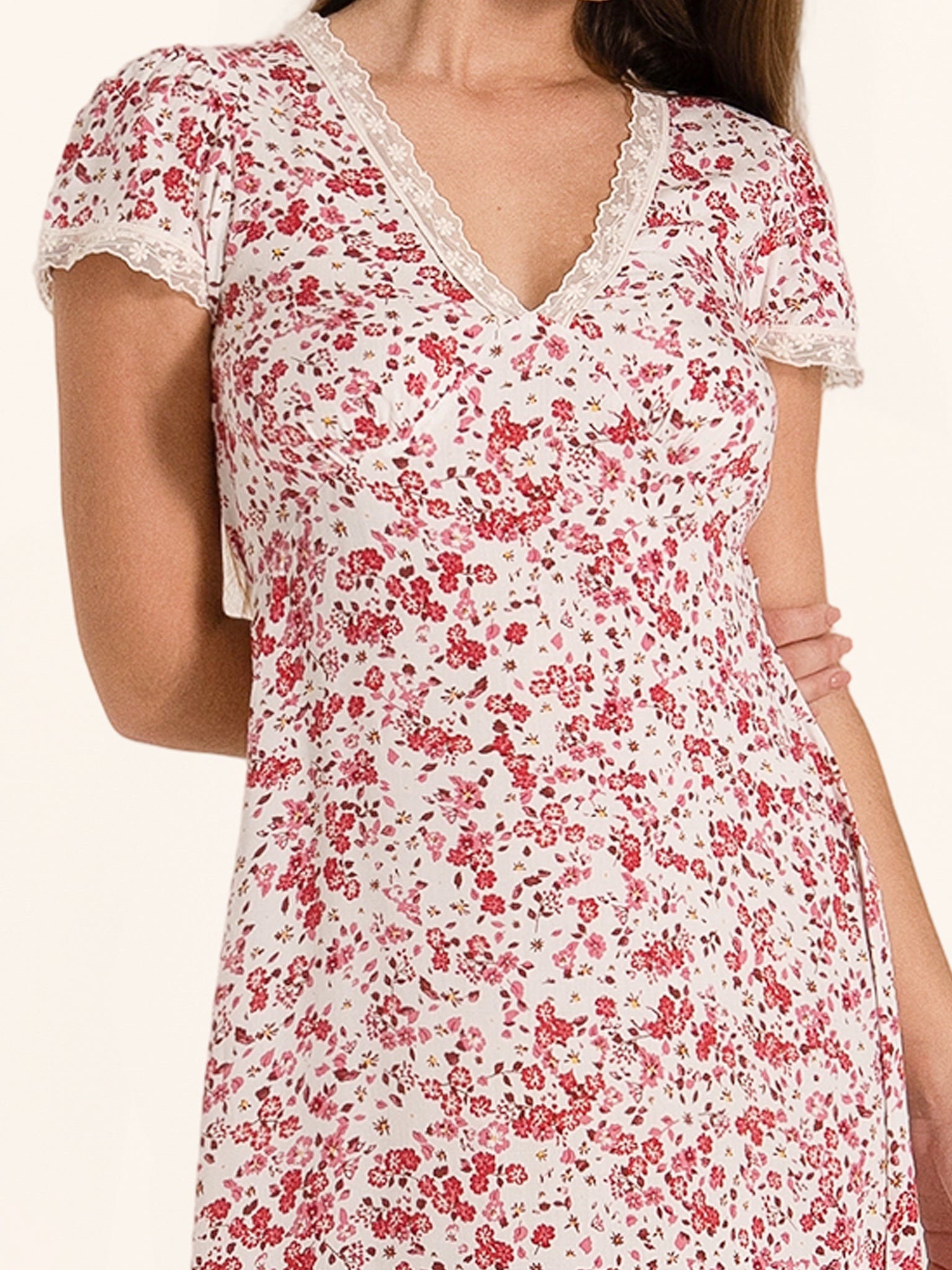 Closeup front detail of red and white floral dress with wrap style fit