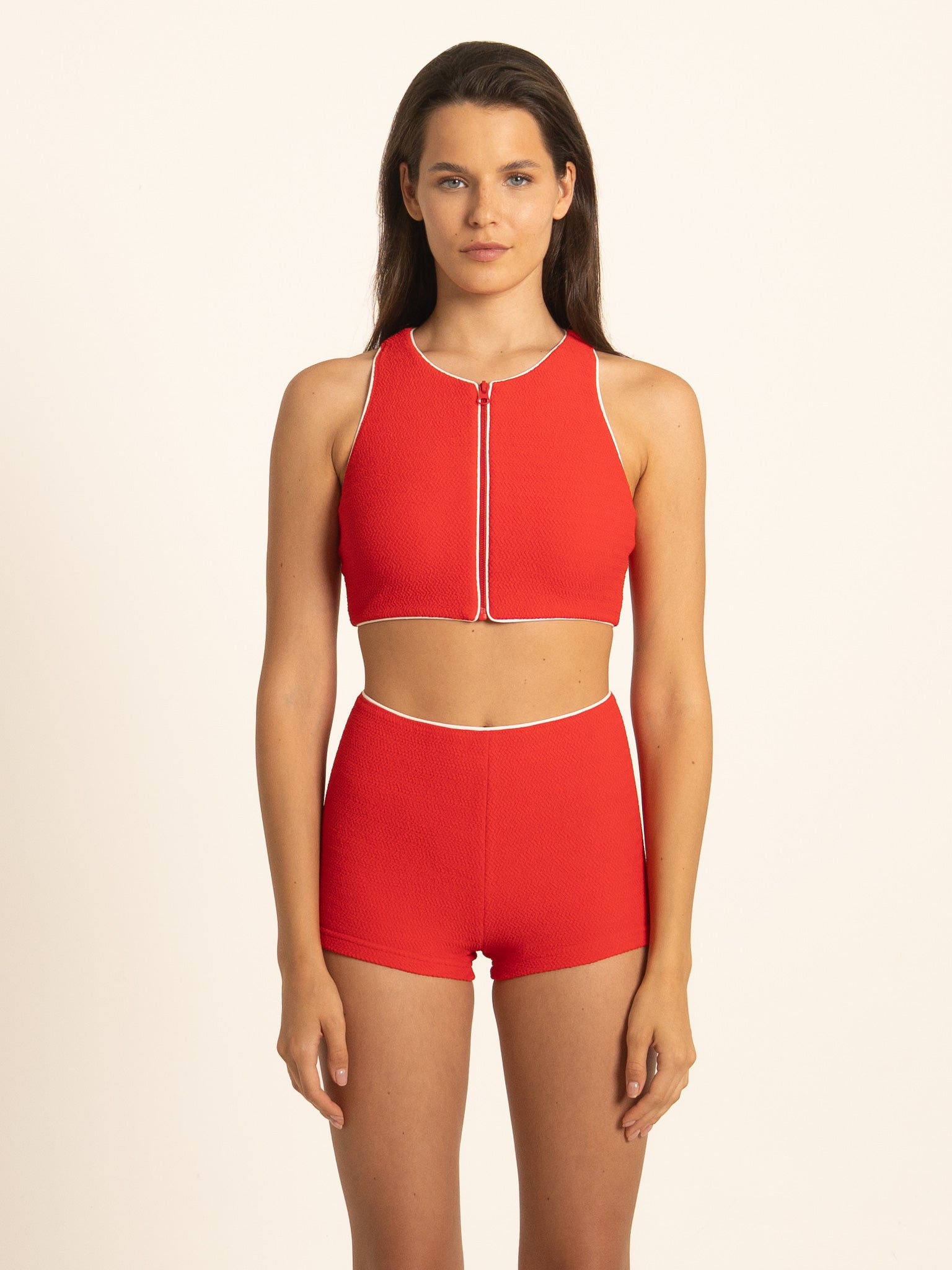 Full front view of the Ruby red zip front tank crop top, offering an elegant athletic look with contrast white piping on the ribbed fabric.