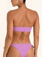Back view of purple strapless bandeau bikini top with minimal coverage.