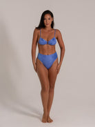 Front view of a model wearing a textured blue bikini set with high-waist bottoms and underwire top.